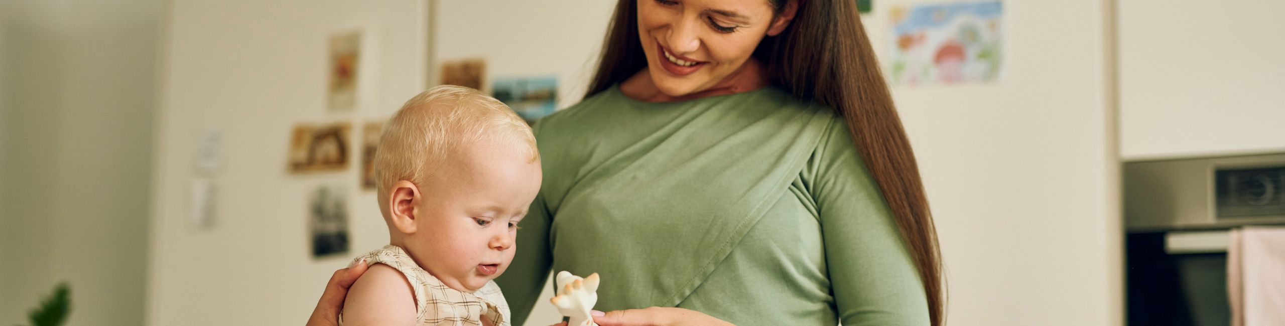 Majka s bebom u kuhinji igra se s popularnom žirafom - bezbrižni trenuci bez brige o alergijama