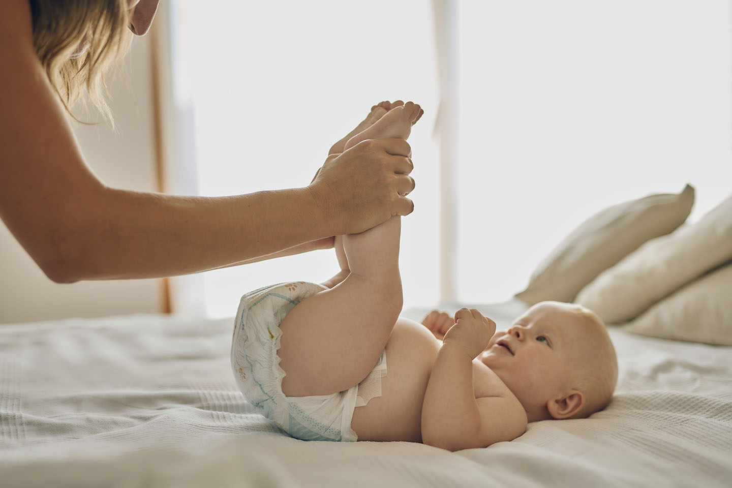 Beba na stolu s nogama u zraku – vrijeme za presvlačenje pelene.