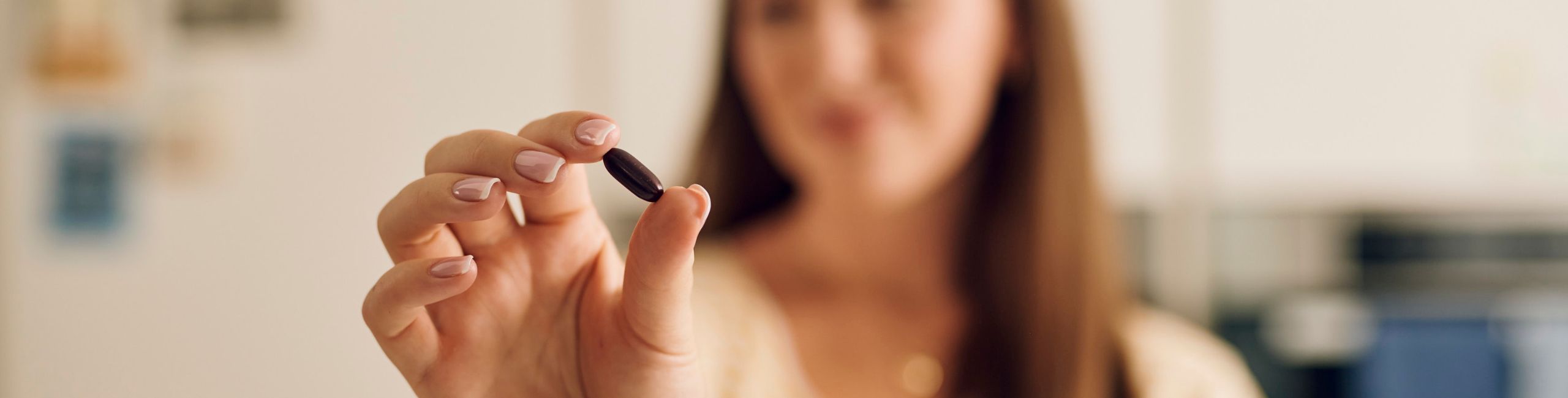 Žena drži Novalac prenatalnu kapsulu s mikrokapsulama željeza Lipofer – optimalna suplementacija tijekom trudnoće.