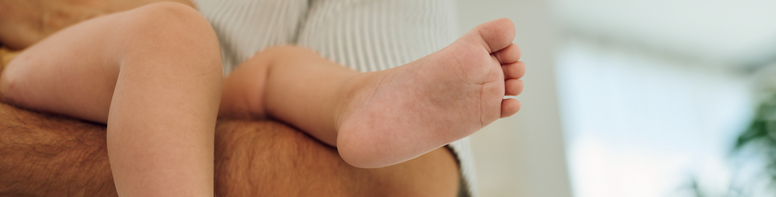 Roditelji drže svoju bebu u naručju – sretni trenuci obiteljske ljubavi.