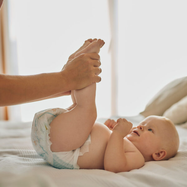 Beba se mijenja dok roditelj pažljivo obavlja presvlačenje pelene. Ovaj trenutak simbolizira svakodnevnu njegu i pažnju koju beba prima od roditelja, osiguravajući joj udobnost i higijenu u ranim fazama života.