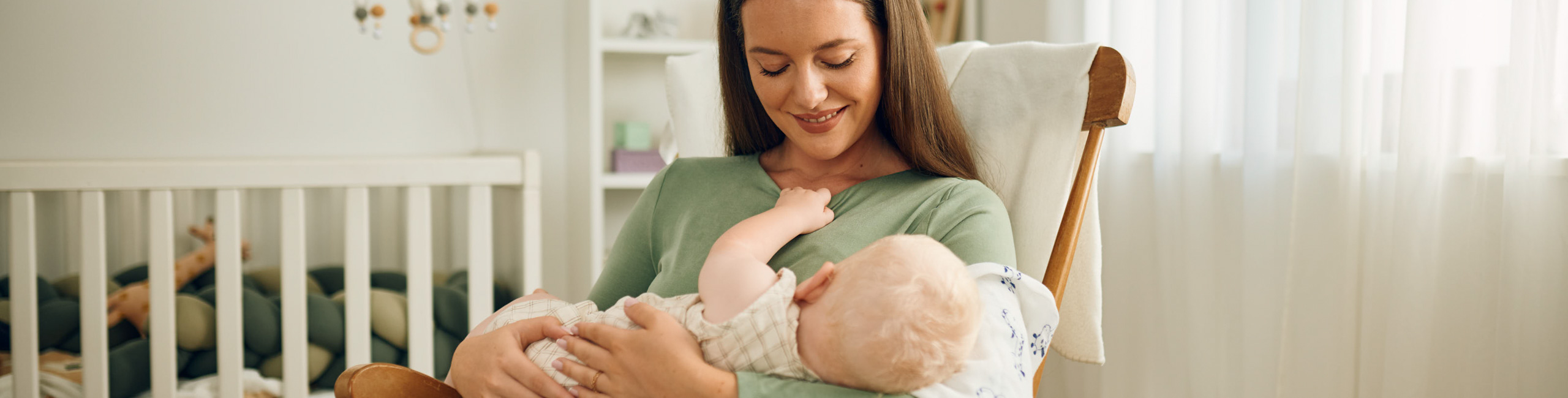 Majka drži bebu nakon hranjenja – trenutak ljubavi i njege.