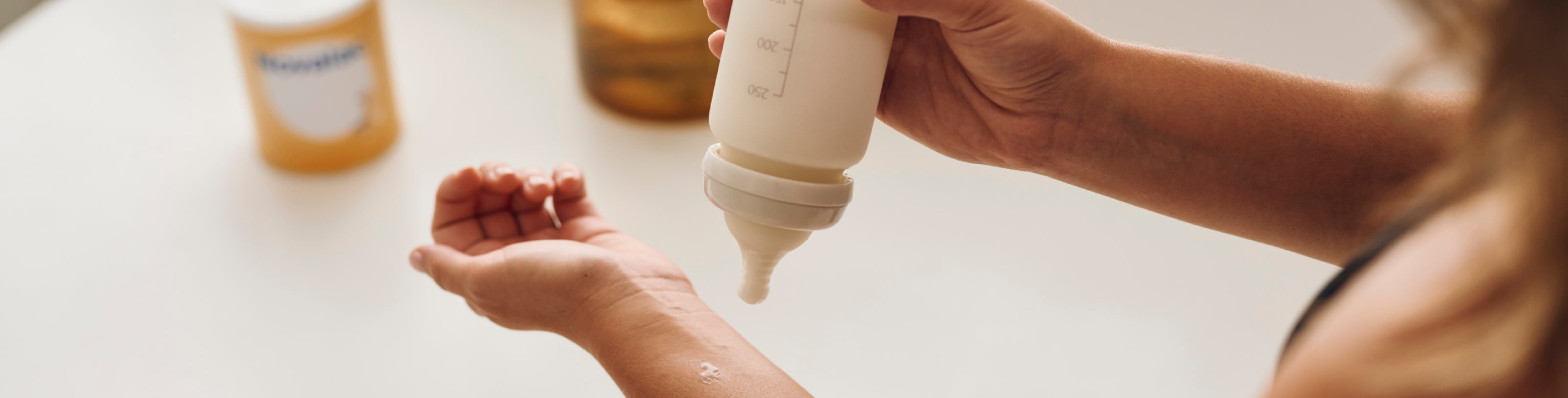 Provjera temperature mlijeka na zapešću – sigurno hranjenje za bebu.