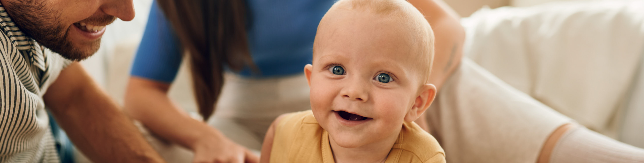 Sretna obitelj - mama, tata i beba zajedno uživaju u igri.
