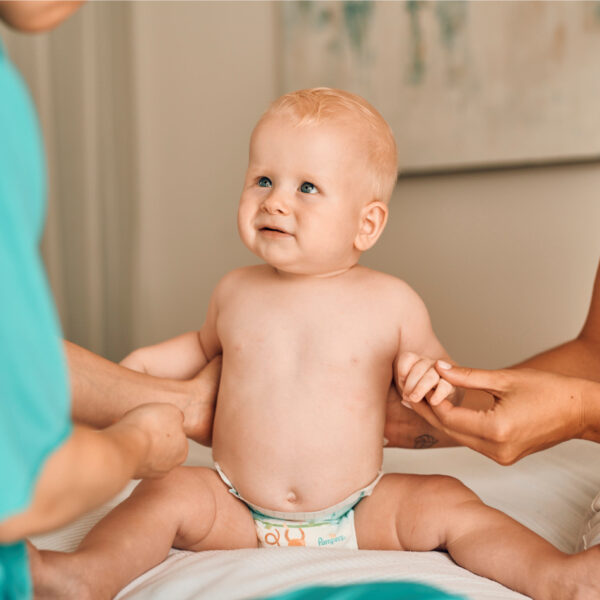 Patronožna sestra pregledava bebu – briga o zdravlju novorođenčeta.