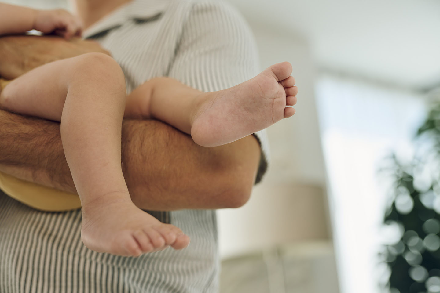Djetetovo stopalo u rukama roditelja – trenutak njege i zaštite.
