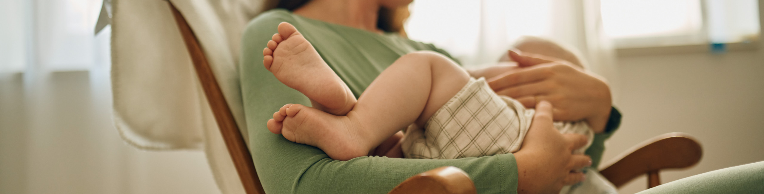 Roditelji drže svoju bebu u naručju – sretni trenuci obiteljske ljubavi.