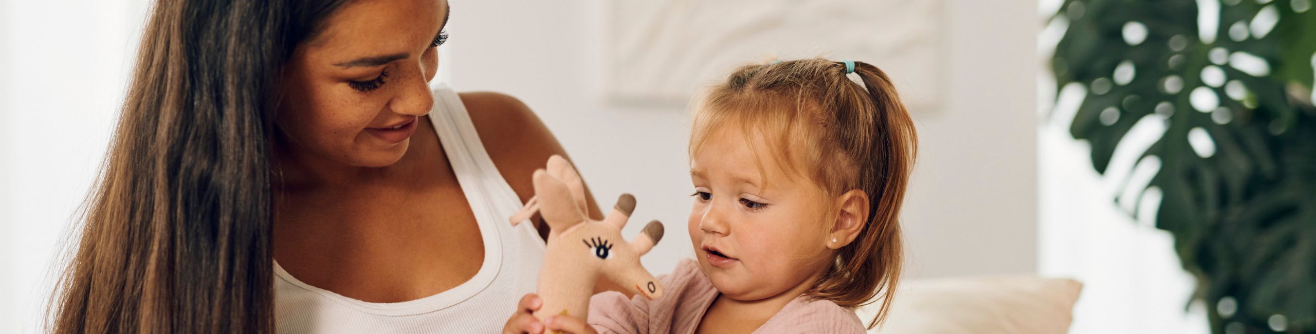 Trudna majka i dijete uživaju u igri sa žirafom – sretni trenuci zajedništva.