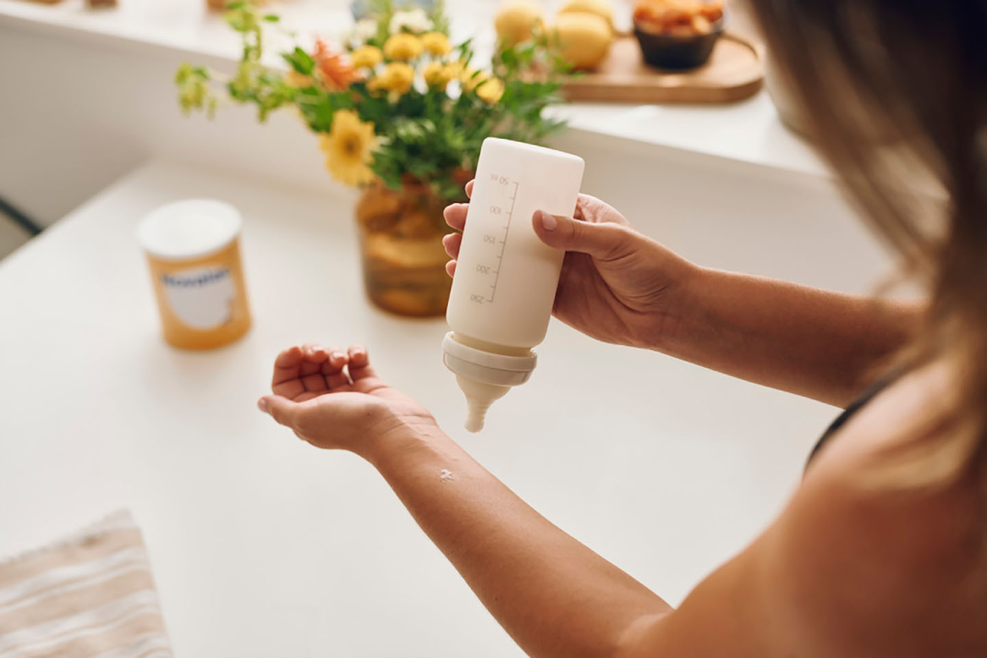 Provjera temperature mlijeka na zapešću – sigurno hranjenje za bebu.