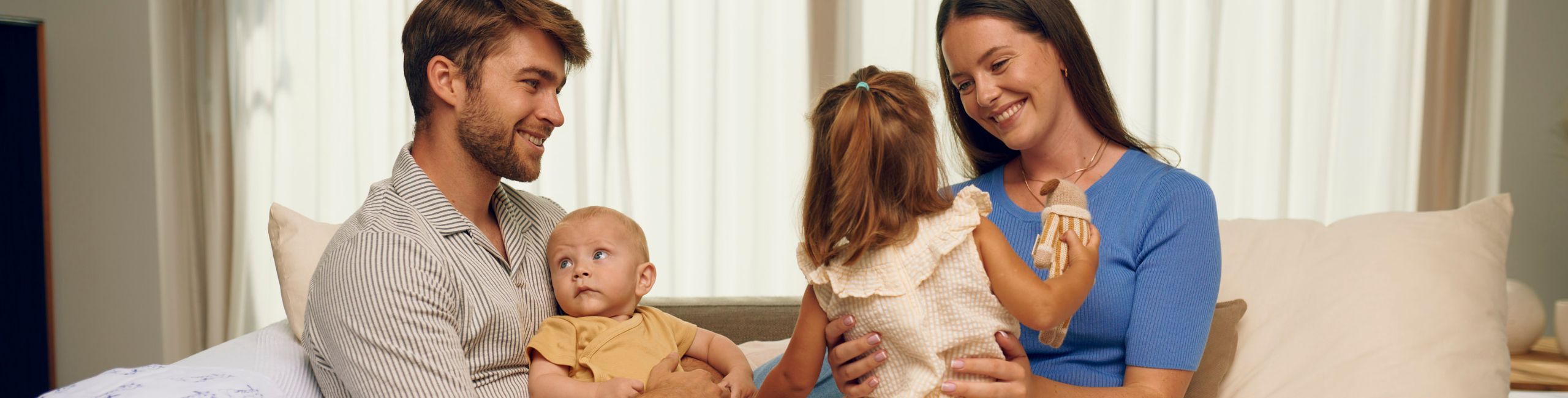 Obitelj zajedno na kauču – sretni trenuci zajedništva.