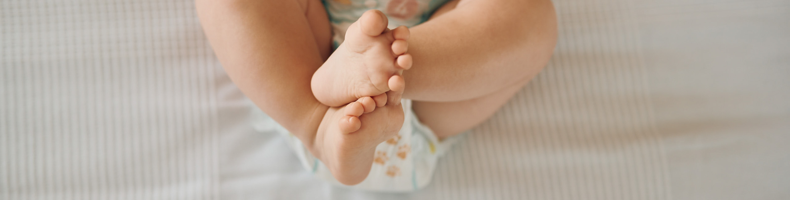 Beba leži s podignutim nogama – znakovi zatvora kod dojenčadi.